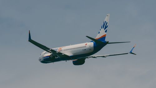 Free A commercial airplane flying against a blue sky, showcasing aviation technology and travel. Stock Photo