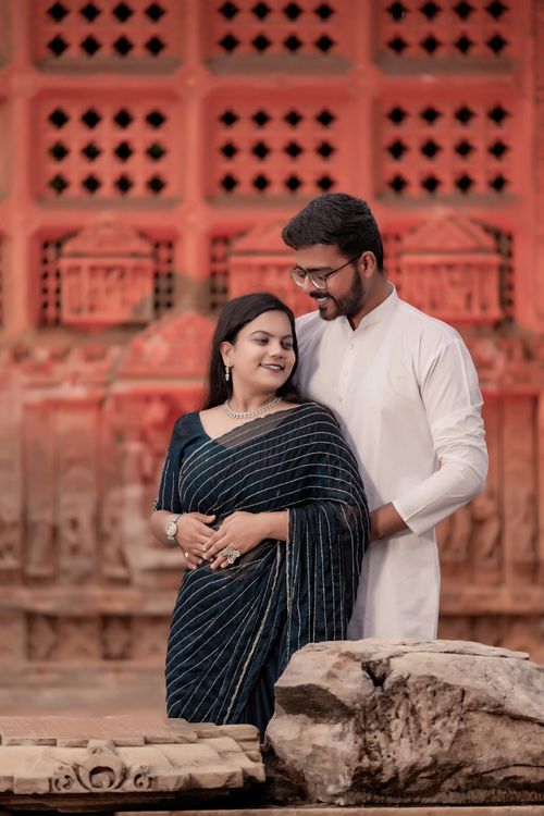 Free Charming couple in traditional dress enjoying a romantic moment in a historic outdoor setting. Stock Photo