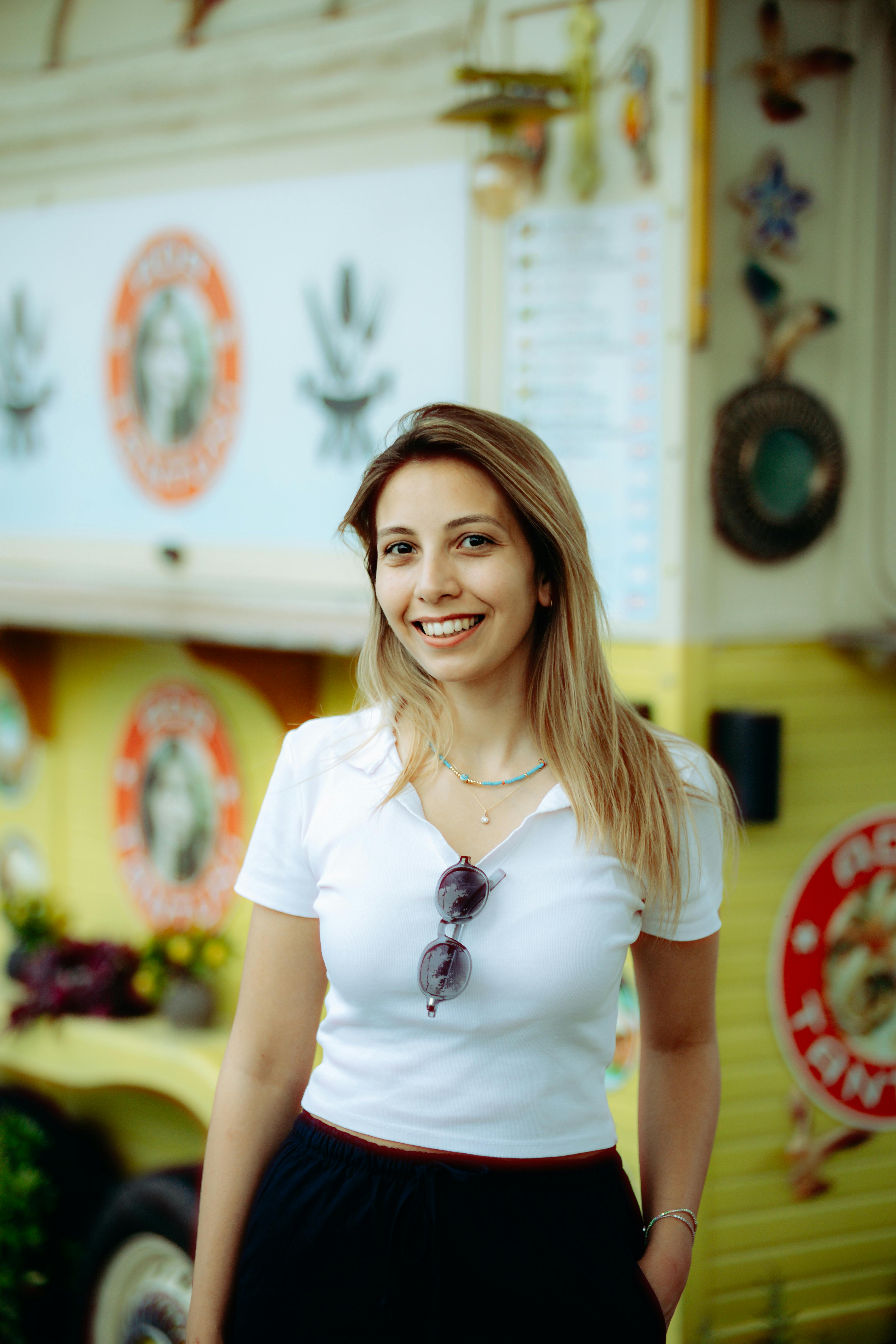 Cheerful woman standing in front of a vibrant food truck, exuding positivity.