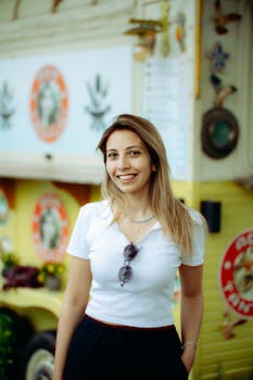 Cheerful woman standing in front of a vibrant food truck, exuding positivity.