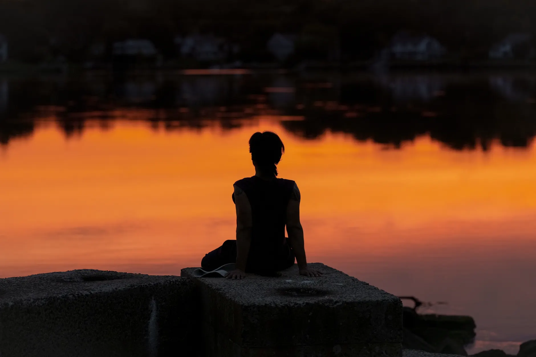 A spiritual coaching client sits in quiet reflection at sunrise, between sessions with a spiritual life coach.