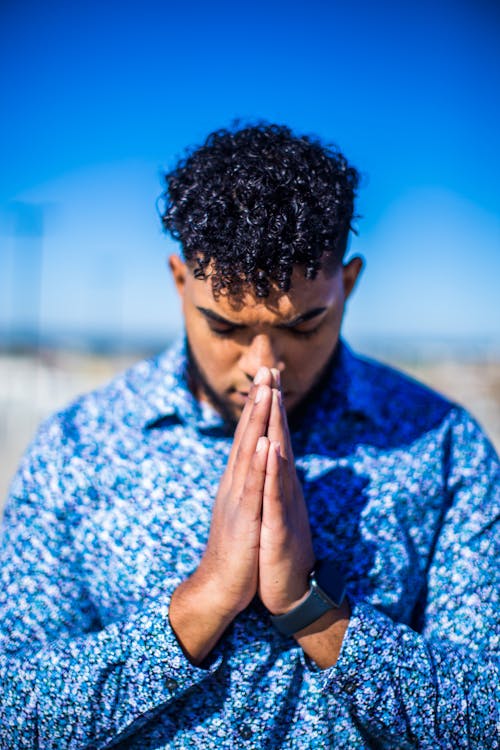 Standing Man in Blue Dress Shirt Praying