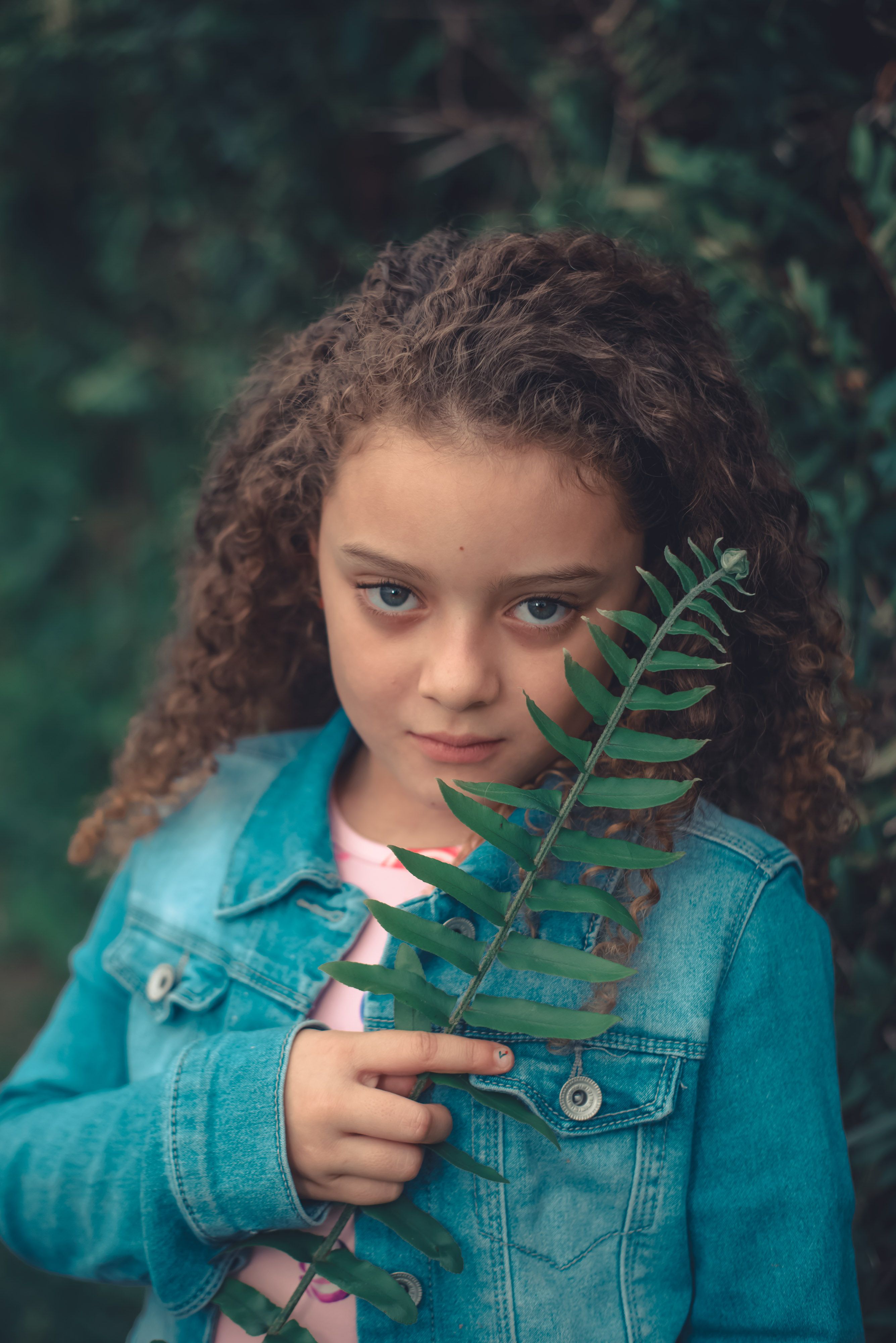 Girl Holding Fern Leaf Outdoors in Denim Jacket · Free Stock Photo