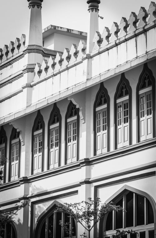 Free Black and white image of a historic building facade featuring arched windows and decorative balconies. Stock Photo