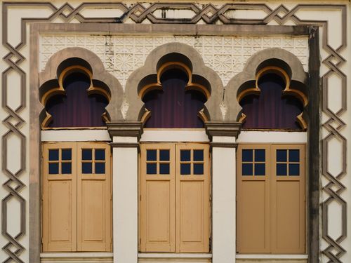 Free Close-up of intricate colonial-style windows on a historical building facade in Singapore. Stock Photo
