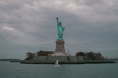 Free The iconic Statue of Liberty in New York with a cloudy sky, symbolizing freedom. Stock Photo