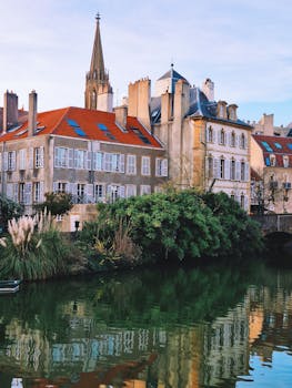 Charming riverside view with historic architecture and reflections in Metz, France.