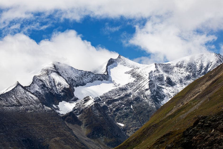Breathtaking view of snow-capped peaks in Korutany, Rakousko, under a dramatic sky.