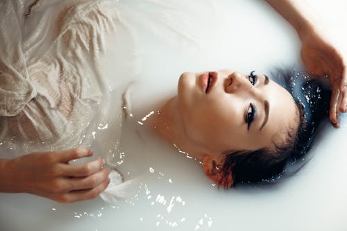 Woman in White Shirt Taking Bath on White Water