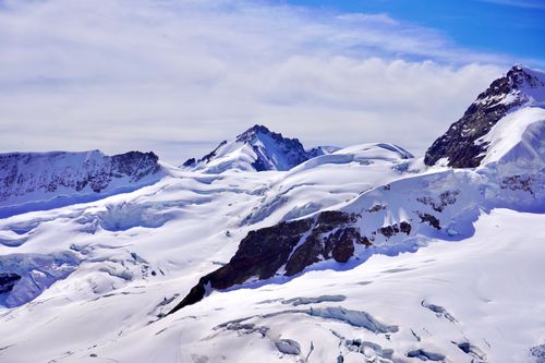 Free Breathtaking view of snowy mountain peaks basking in clear blue skies over the Alps. Stock Photo