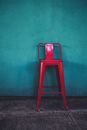 Red Chair Beside Teal Wall