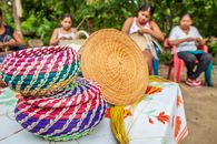 African women weaving colorful bamboo baskets in garden