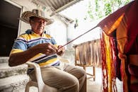 在哥伦比亚莫罗阿，老人们在户外制作传统纺织品