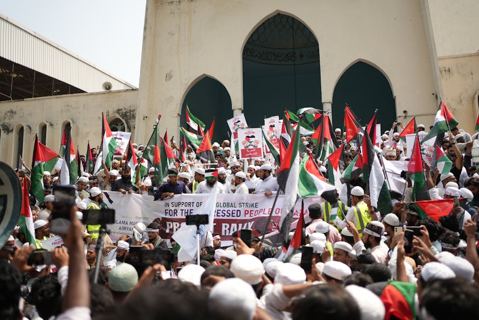 Crowd gathers in Dhaka for a pro-Palestinian demonstration waving flags and banners.