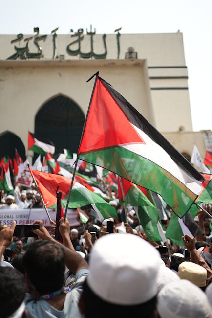 A lively pro-Palestinian protest in Dhaka, featuring flag waving and a large crowd expressing solidarity.
