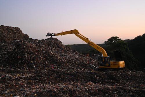 Excavator on Work on a Landfill 