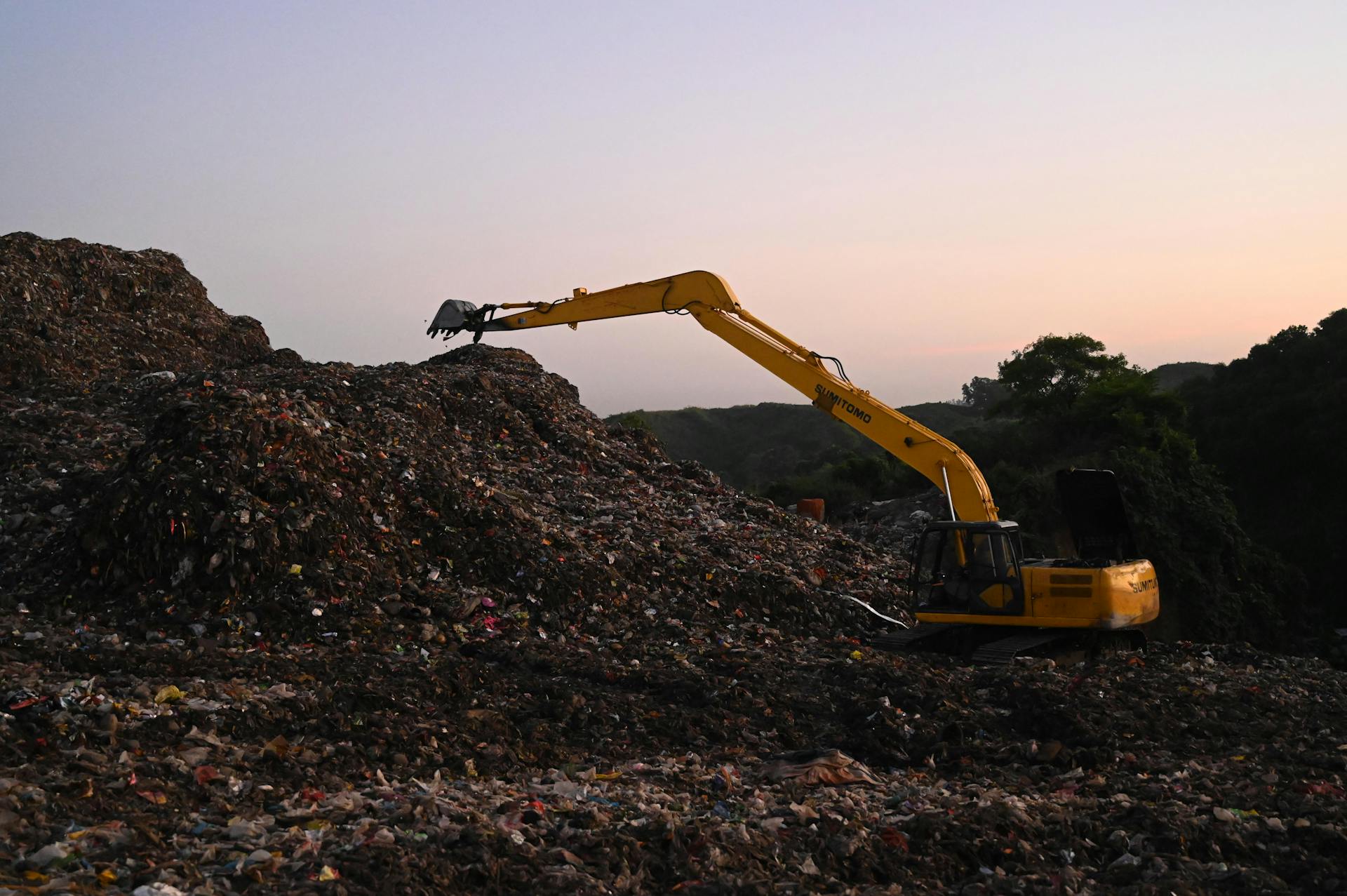 Excavator on Work on a Landfill