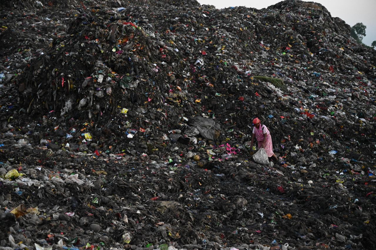 A person scavenges a landfill.