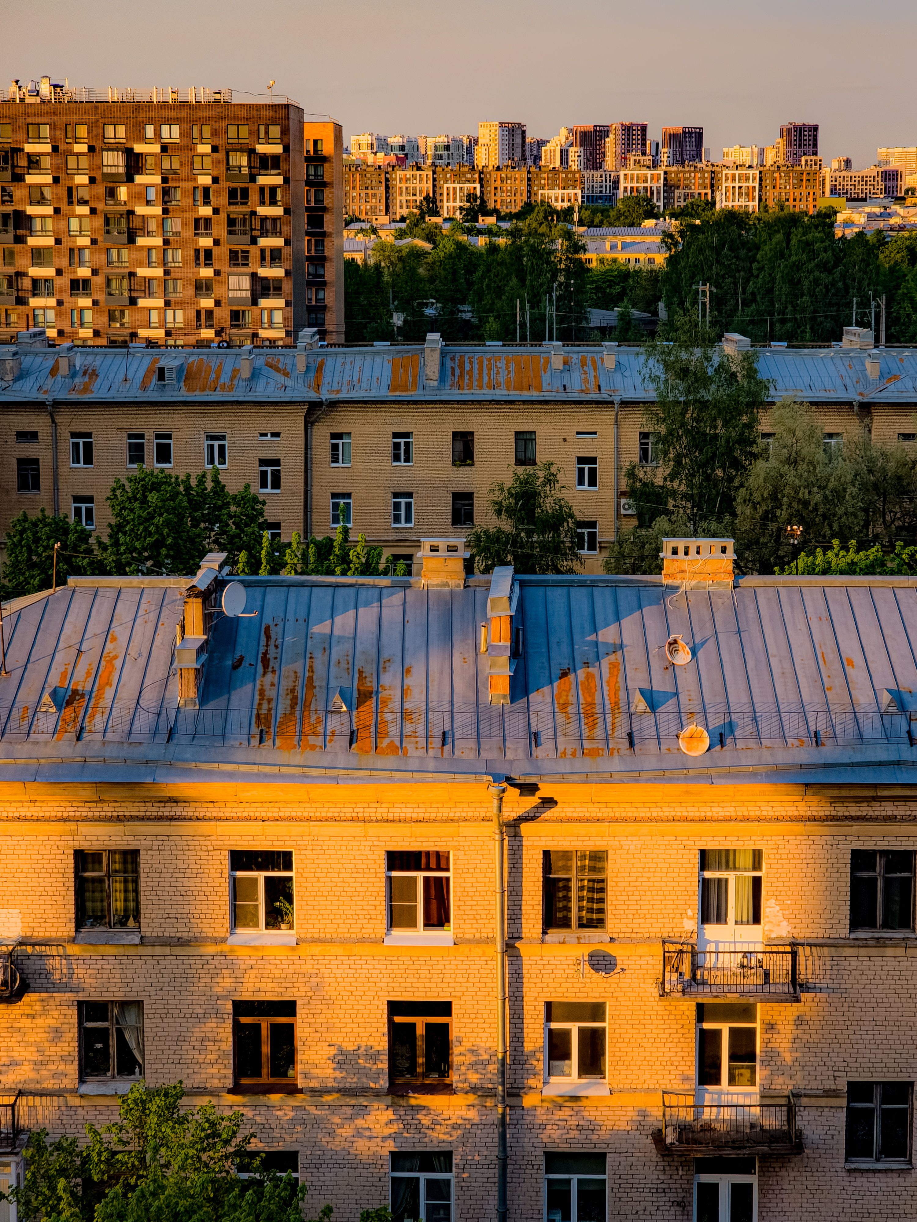 Aerial view of layered residential buildings under warm sunset light showcasing urban architecture.