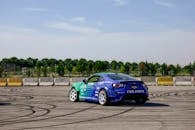 Blue Racing Car Drifting on Open Track