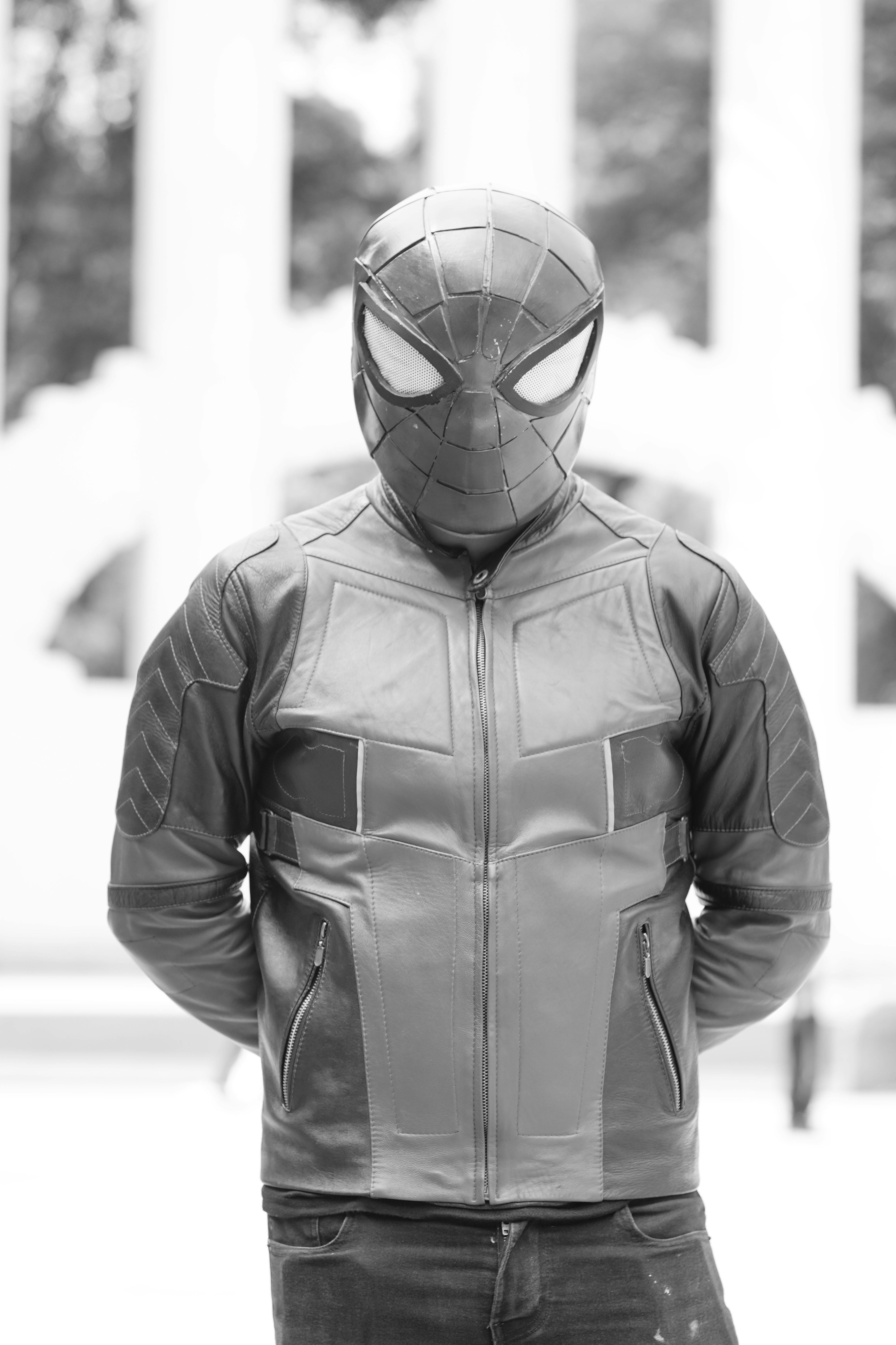 Monochrome image of a person in a superhero suit, featuring a detailed mask and jacket.
