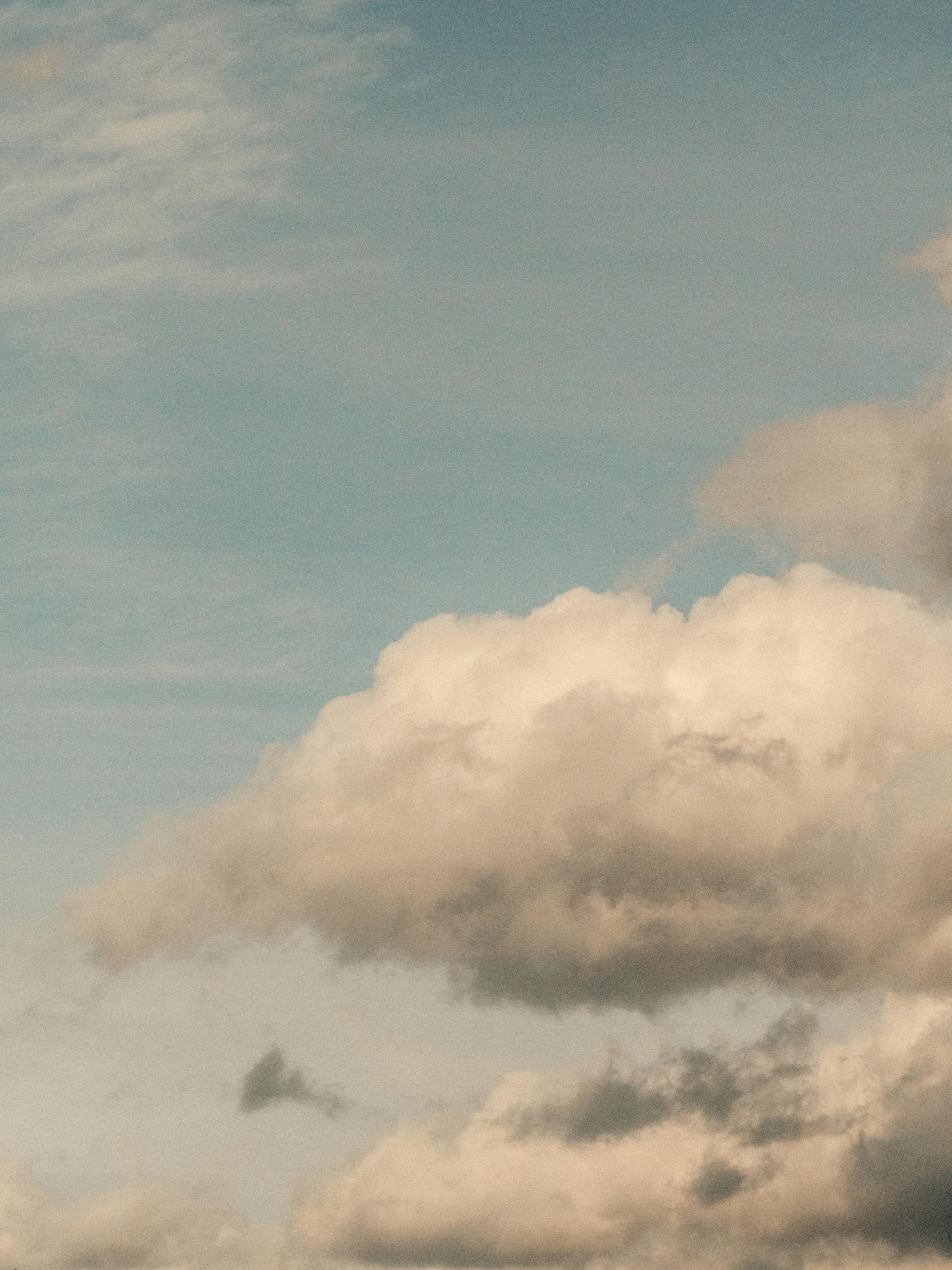 Fluffy white clouds float gracefully against a serene blue sky, perfect for tranquil backgrounds.