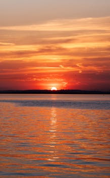 Breathtaking sunset view over calm ocean with vivid colors reflecting in the water.