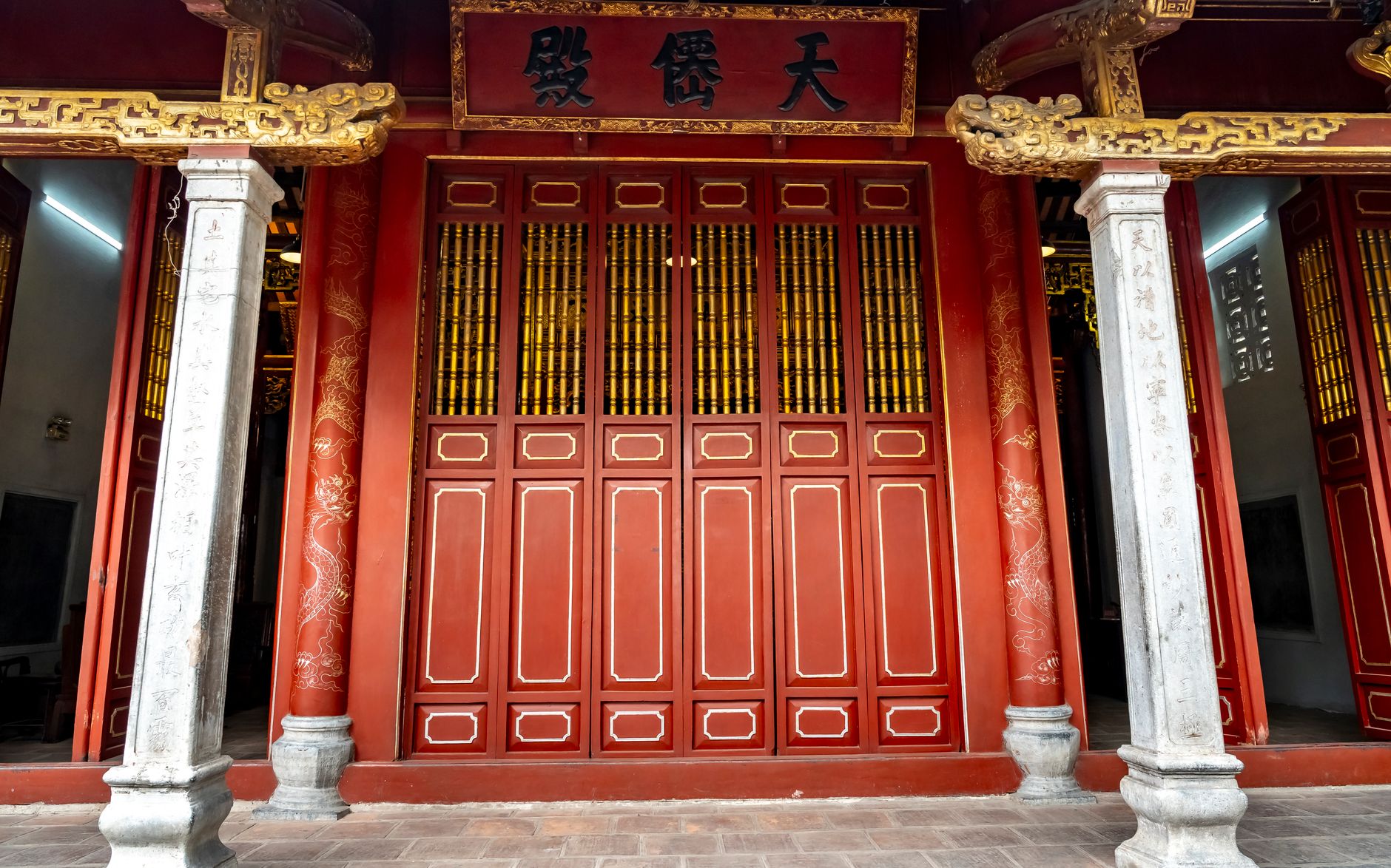 Intricately designed red and gold temple entrance showcasing traditional Asian architecture.