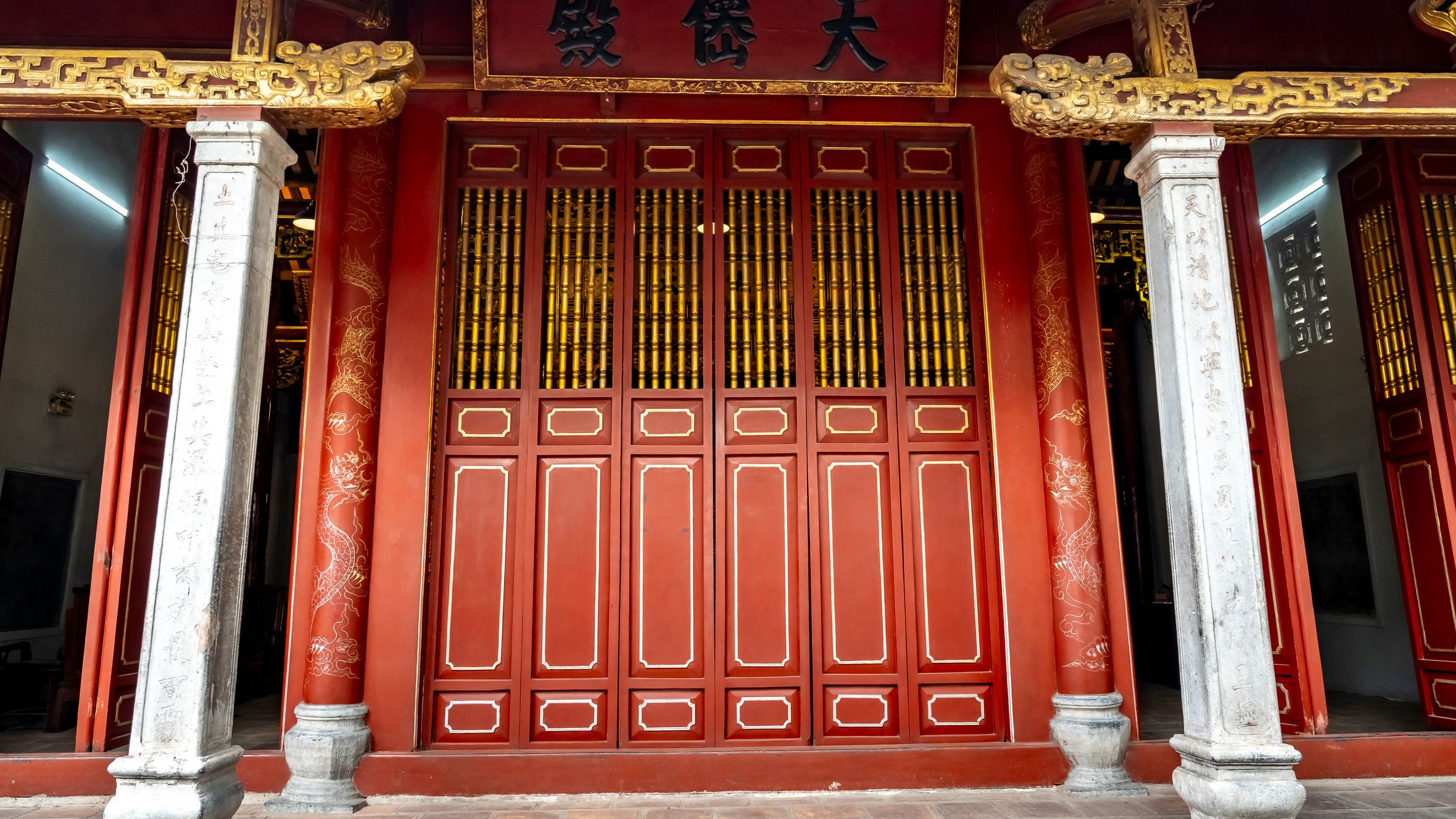 Intricately designed red and gold temple entrance showcasing traditional Asian architecture.