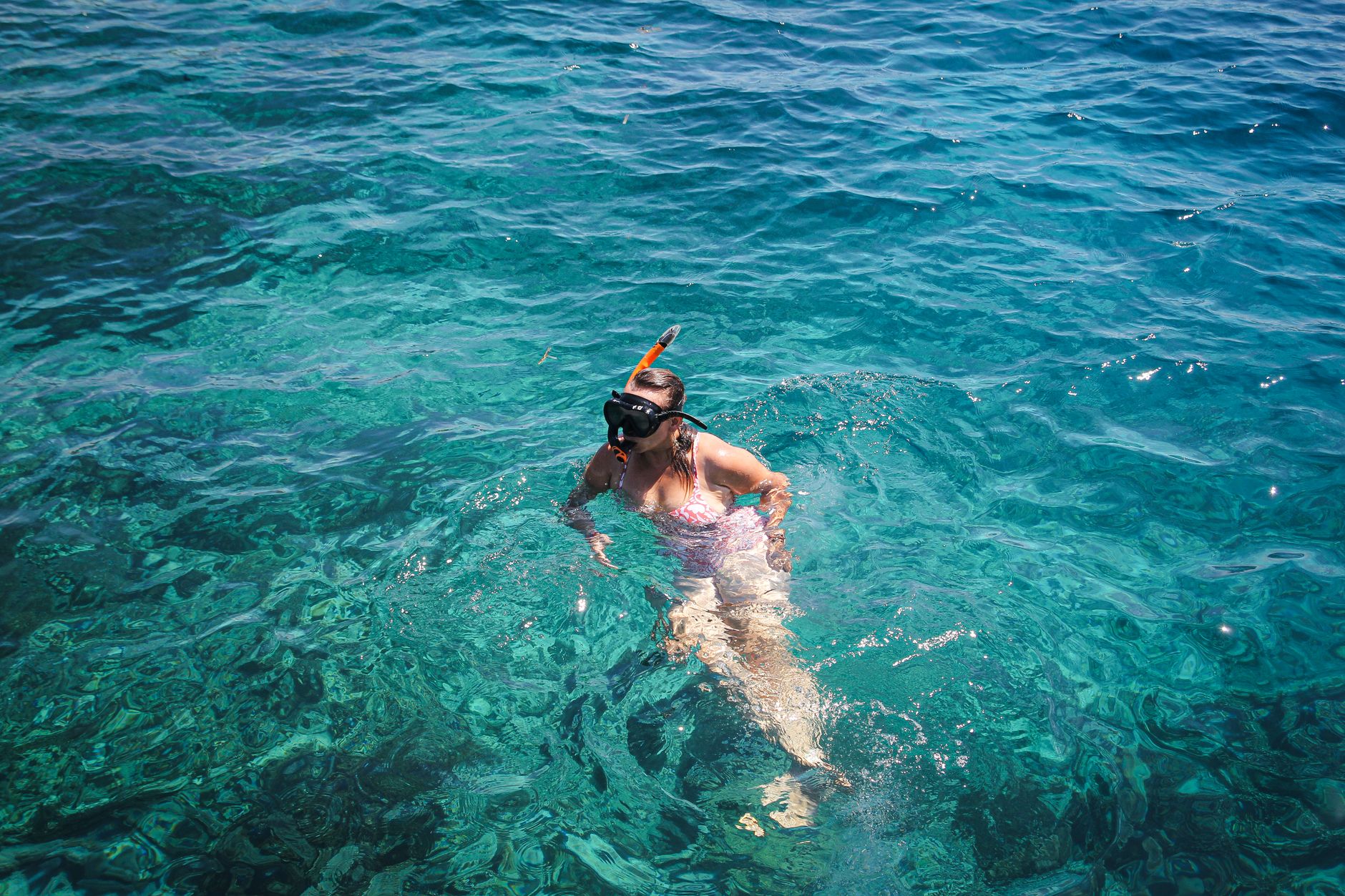 Mujer haciendo snorkel en las claras aguas turquesas de East Nusa Tenggara, Indonesia.
