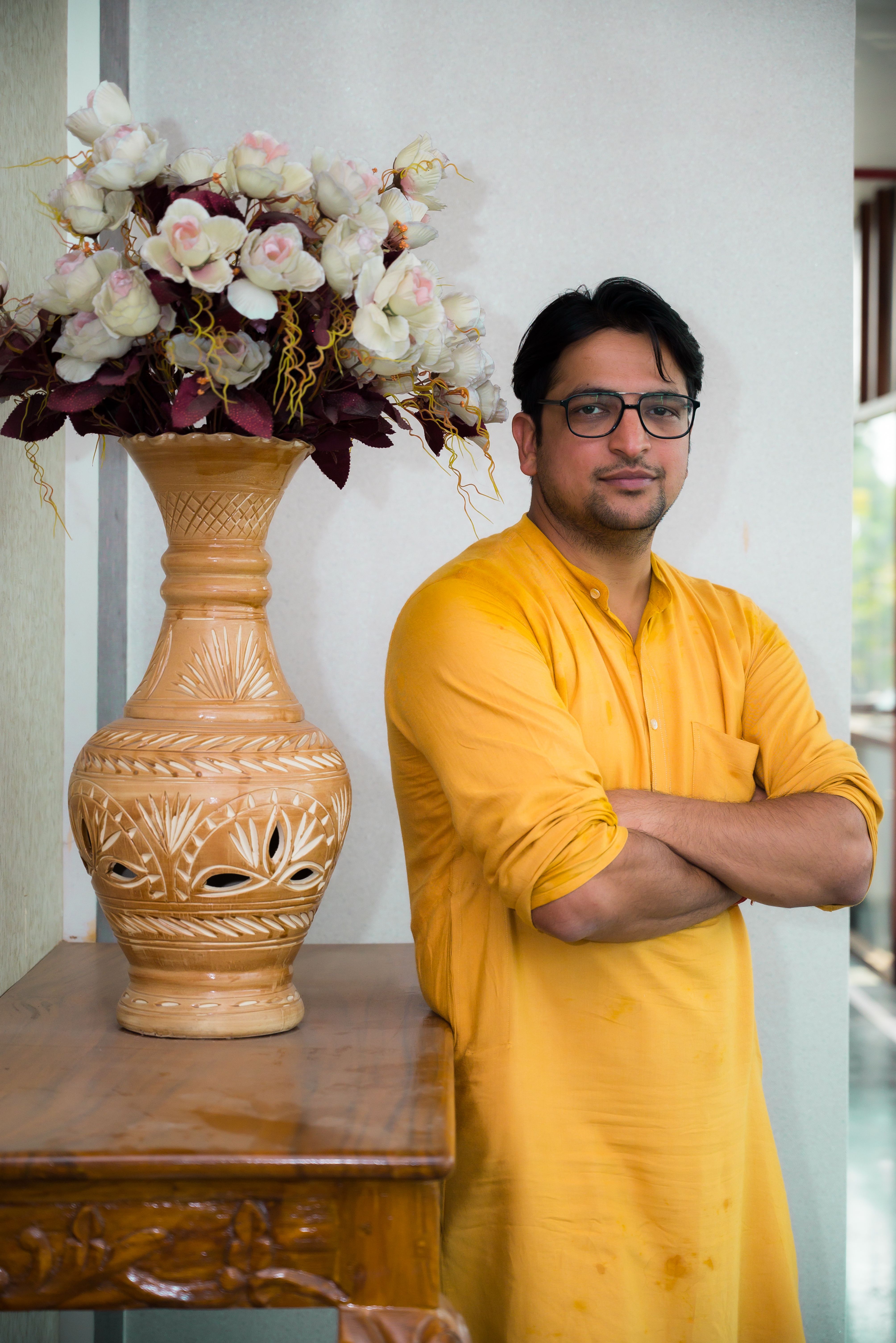 Man in Traditional Attire with Floral Vase