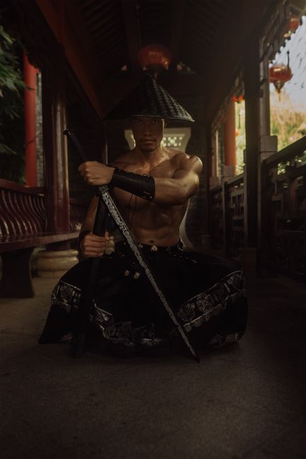 Powerful image of a samurai warrior in traditional attire holding a sword, indoors.
