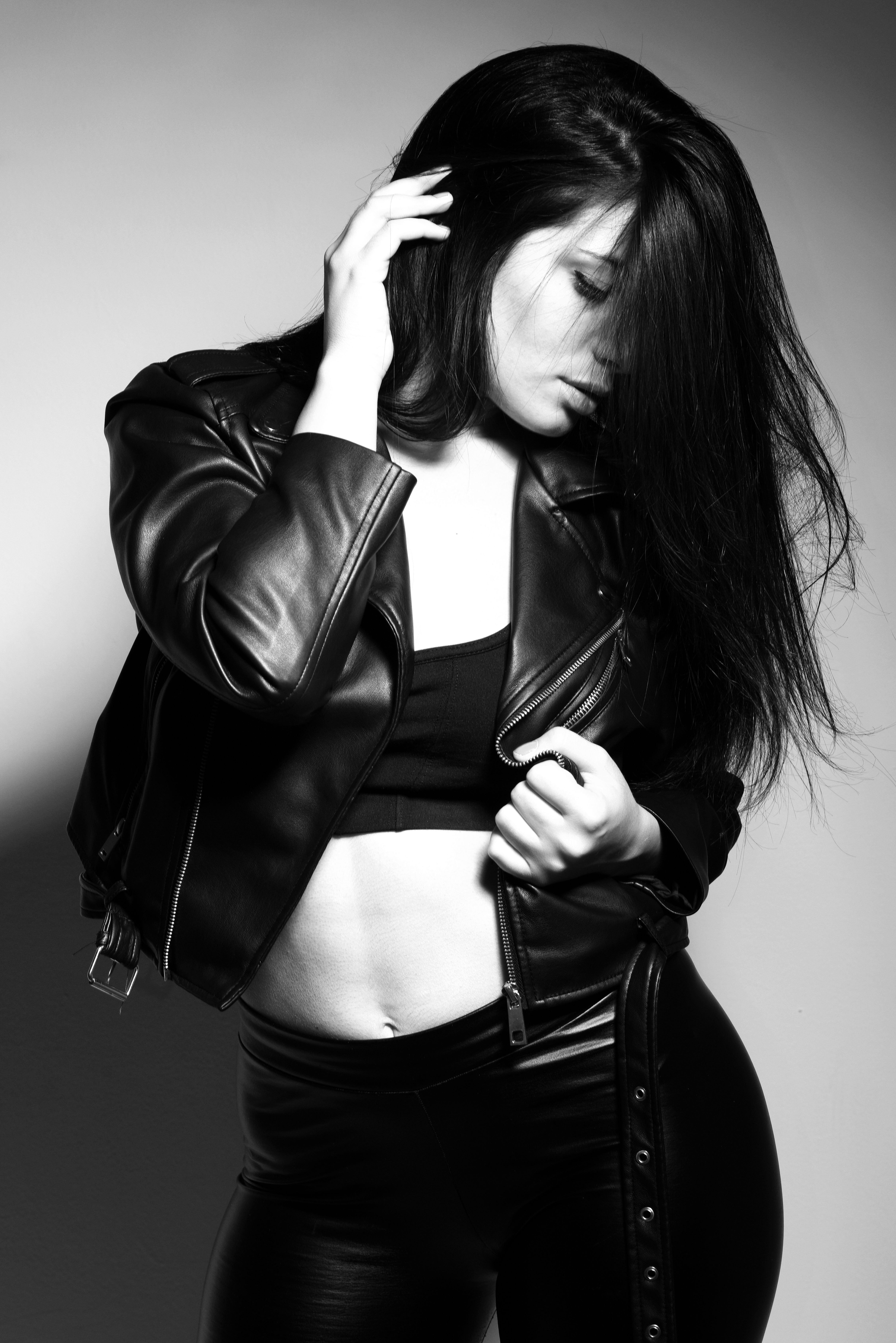 Artistic black and white portrait of a woman wearing a stylish black leather outfit.