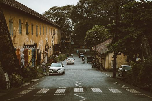 A picturesque street in Galle, Sri Lanka, showcasing vintage architecture and lush surroundings.