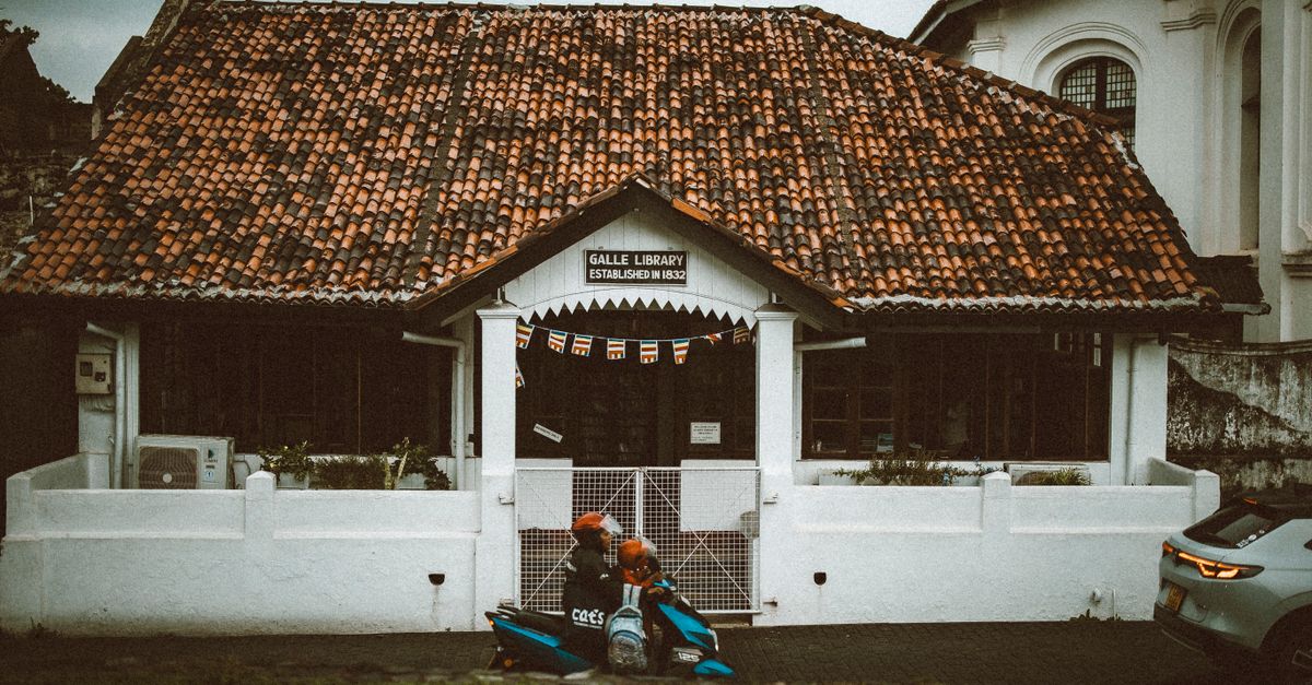 Historic Galle Library with rustic charm and a parked scooter in Sri Lanka.