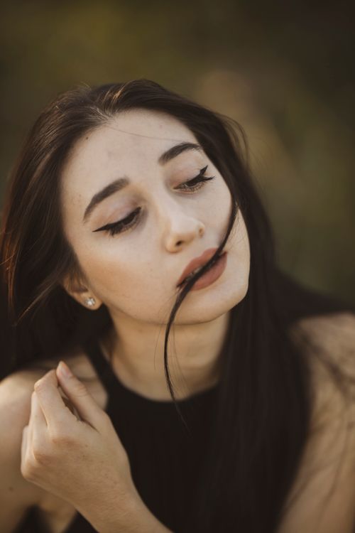 Free Close-up outdoor portrait of a young woman with flowing hair and elegant pose. Stock Photo