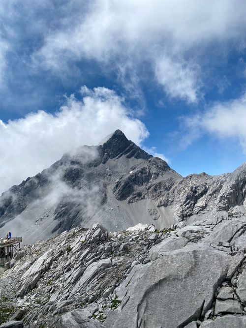 Free Dramatic mountain landscape with rocky peaks and clouds under a blue sky. Stock Photo