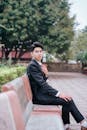 Young Man in Suit Sitting on Park Bench