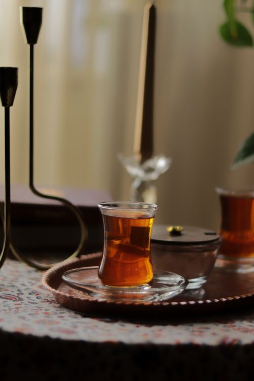 Free A serene setting featuring a teacup on a copper tray with candles and warm tones. Stock Photo