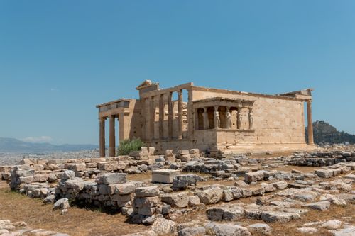 Free View of the historic Erechtheion temple ruins under a clear blue sky in Athens, Greece. Stock Photo