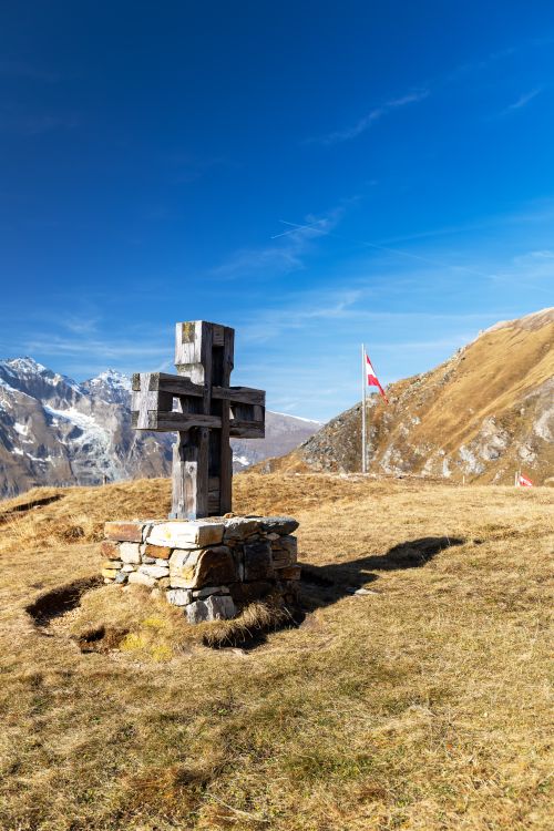 Free Wooden cross amidst the majestic Kärnten Alps in autumn, under a clear blue sky. Stock Photo