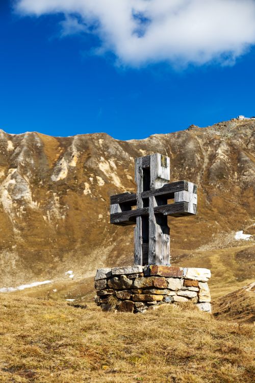 Free Wooden cross on a stone base amidst autumn mountains in Kärnten, Austria. Stock Photo