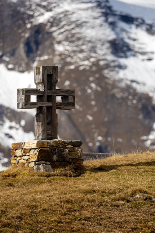 Free Rustic wooden cross set against snowy Carinthian mountains, depicting serene alpine wilderness. Stock Photo