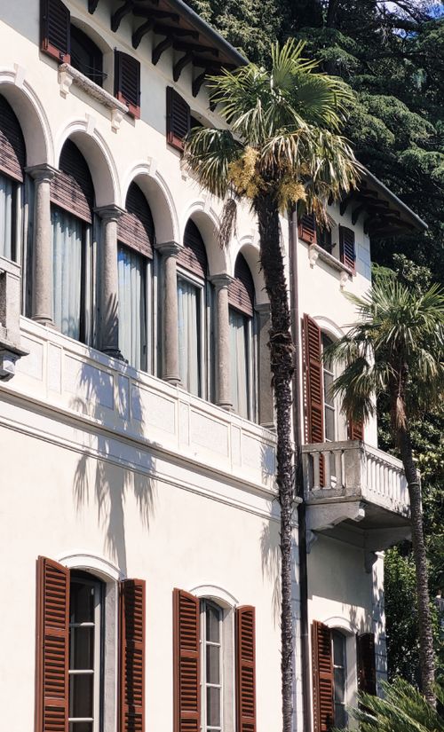 Free A beautiful Mediterranean-style villa with palm trees, showcasing classic architecture and lush greenery. Stock Photo