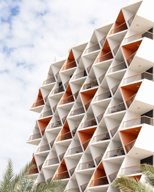 Stylish architectural facade in Dubai with geometric patterns and palm leaves.