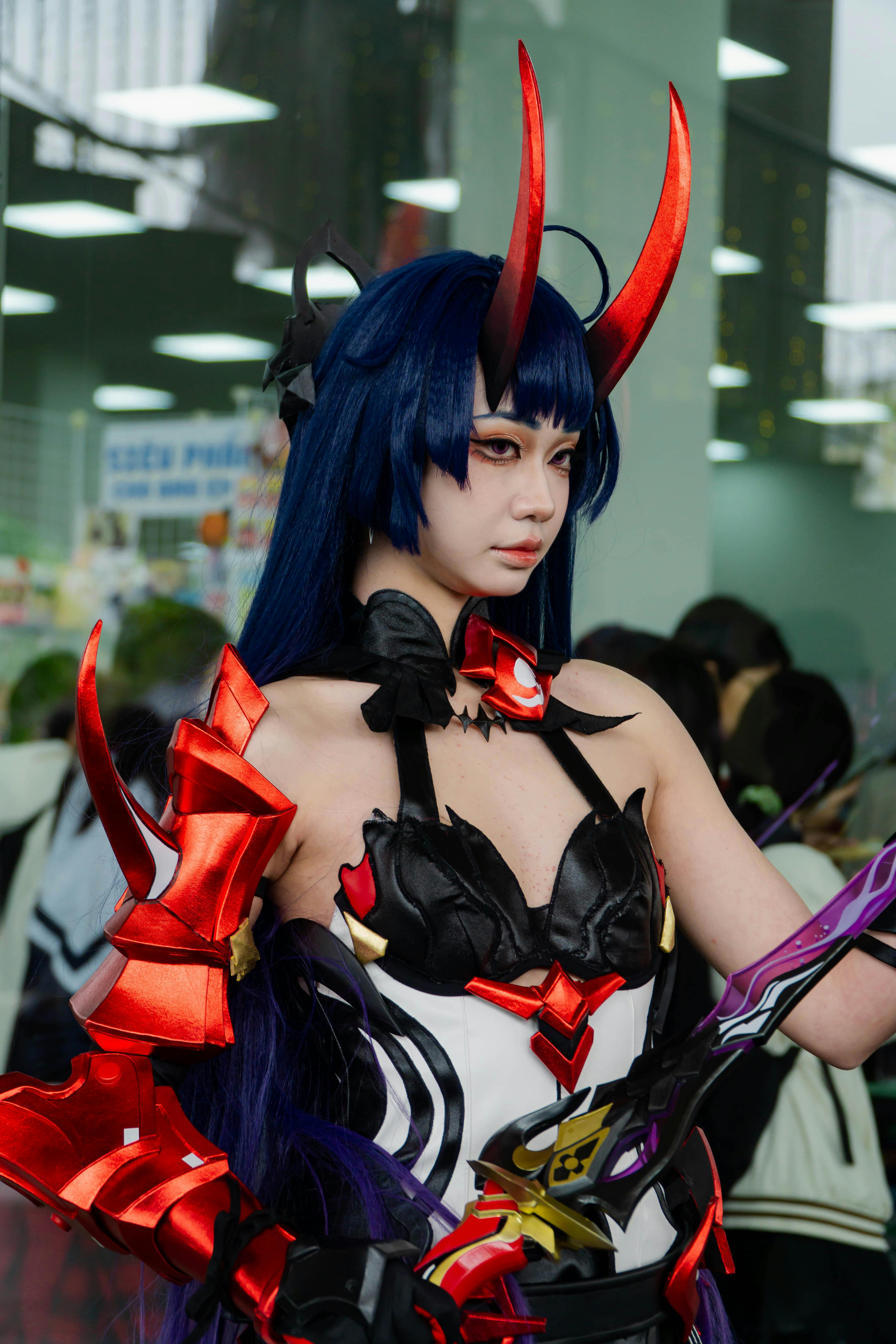 Vibrant cosplay character in detailed costume at an indoor event, showcasing creativity and culture.