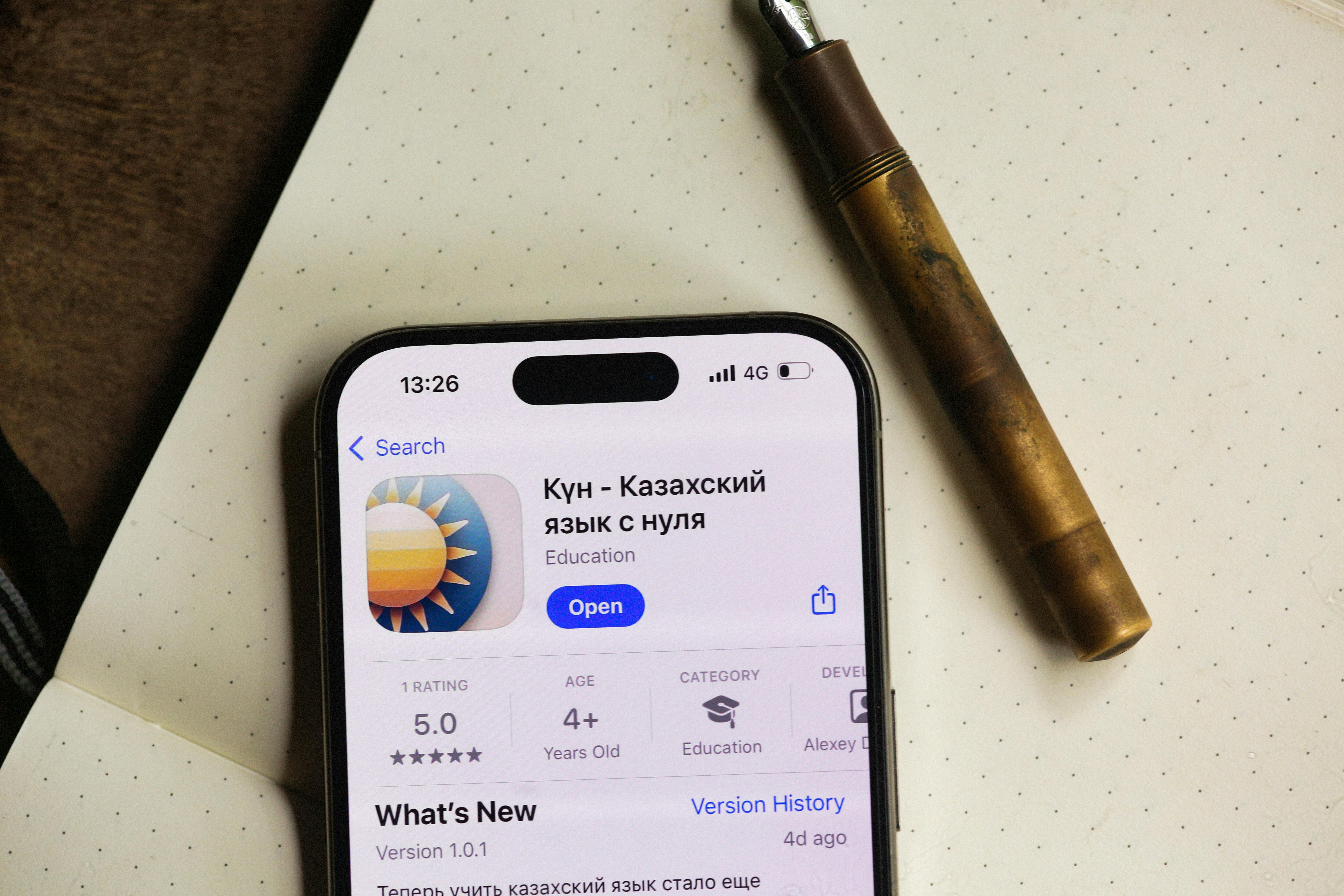 Gratis Layar telepon pintar menunjukkan antarmuka aplikasi pendidikan dengan pena di dekatnya pada kertas bertitik. Foto Stok