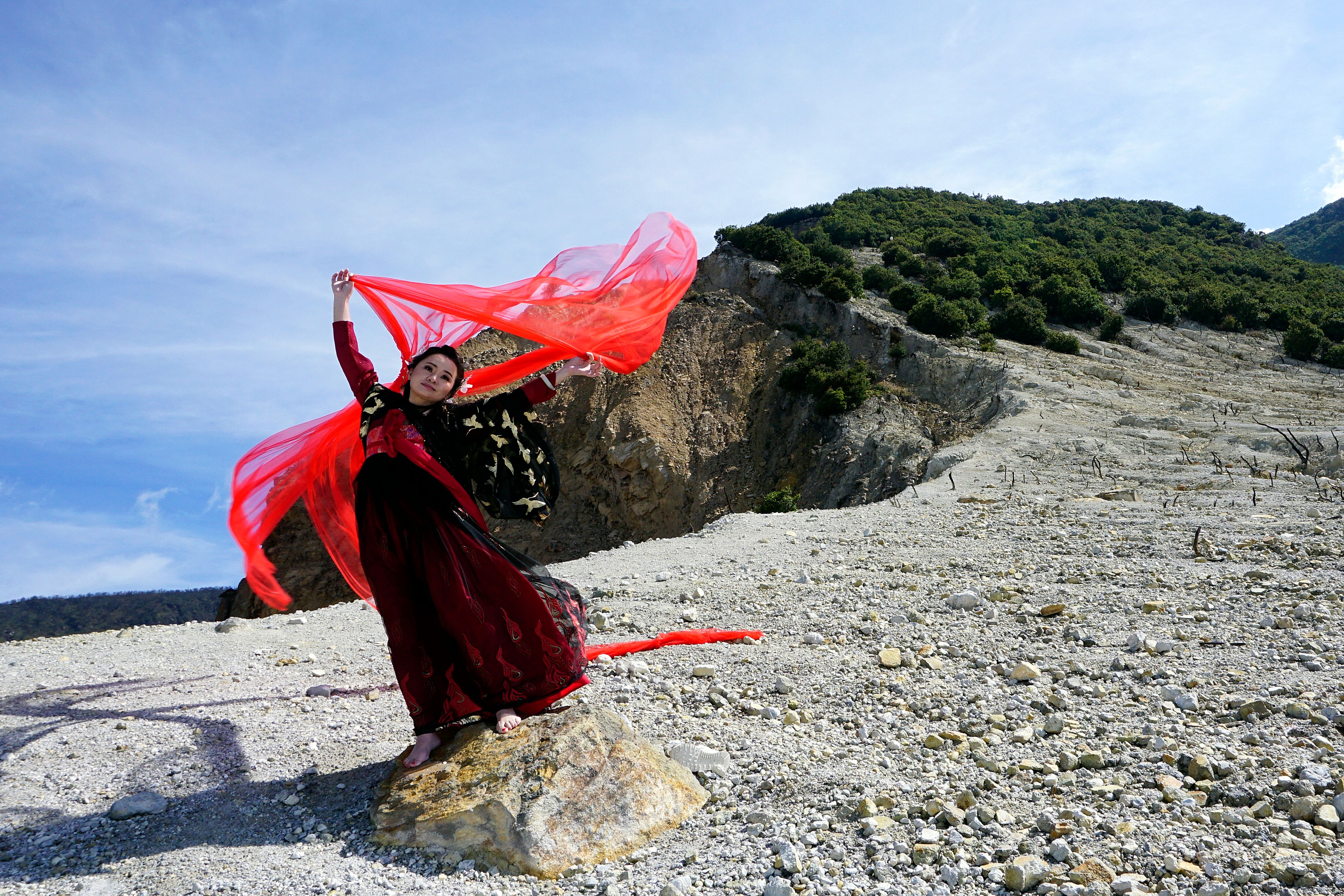 Woman in Red Dress Posing in Rocky Landscape · Free Stock Photo