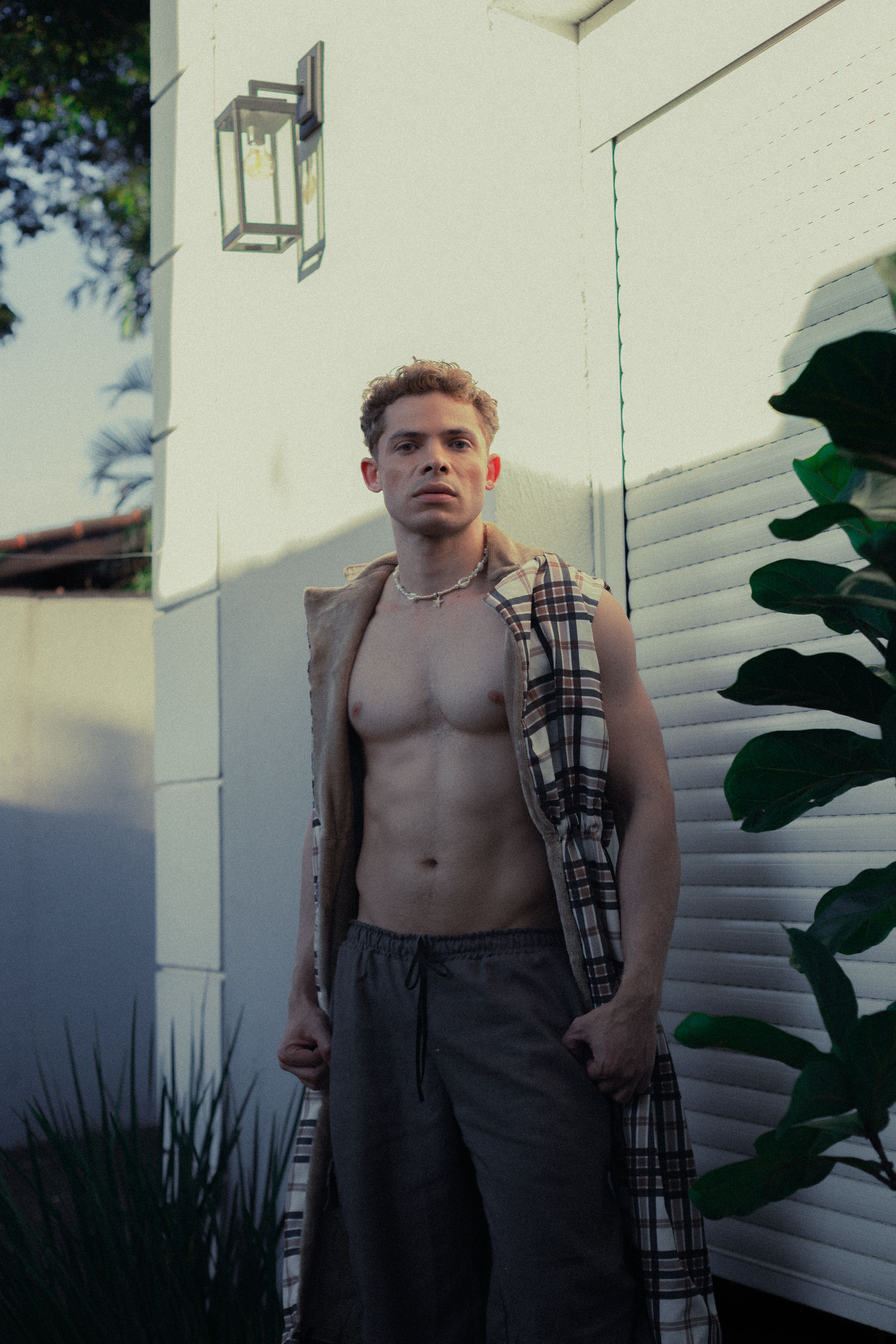 Casual portrait of a man outdoors in a São Paulo garden, exuding confidence.