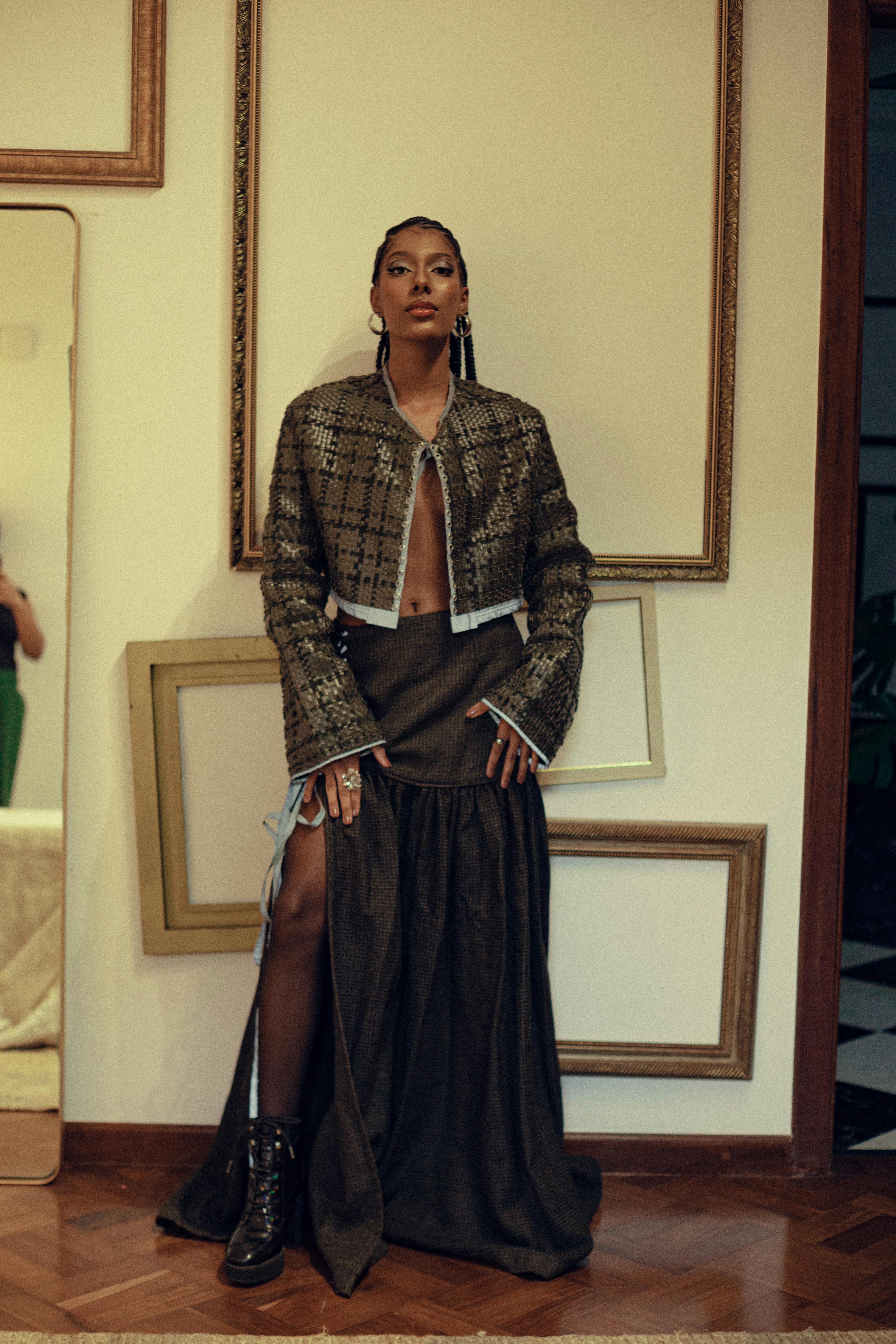 Stylish portrait of a woman in a chic outfit, set against framed art in São Paulo.